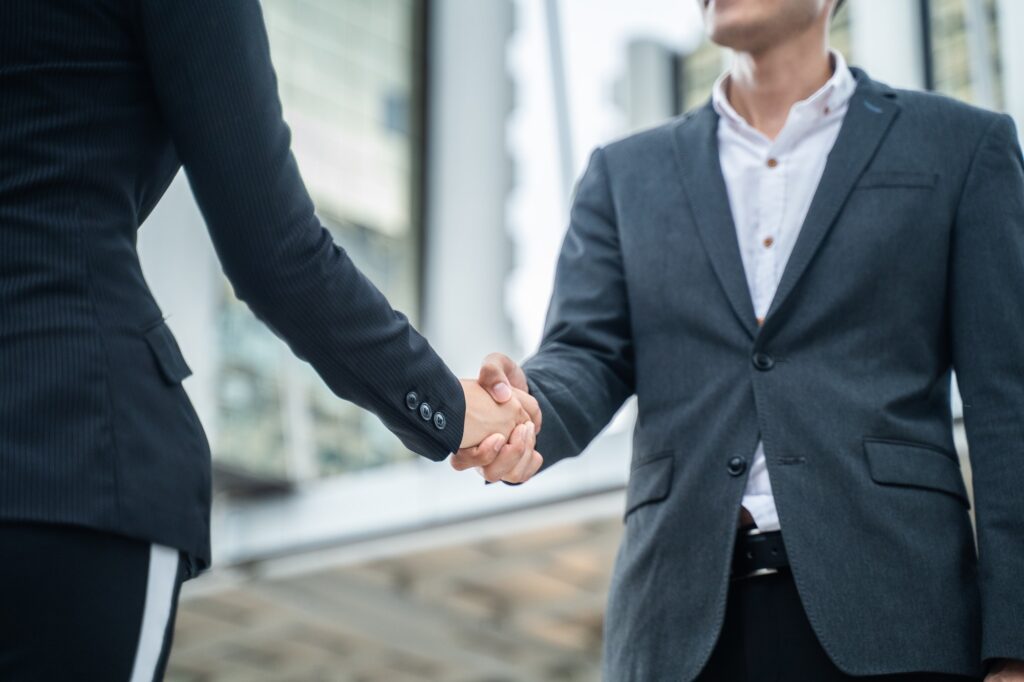 Close up of Asian young business man doing handshake after complete the negotiation in city.