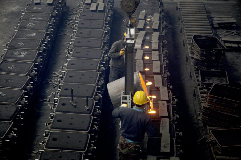 workers in a foundry at the melting furnace