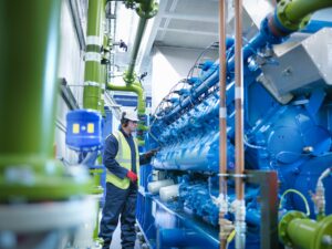 Worker with gas fired generator in gas fired power station