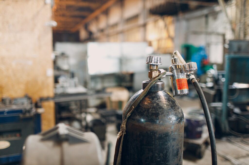 Iron gas cylinder for welding products on factory background.