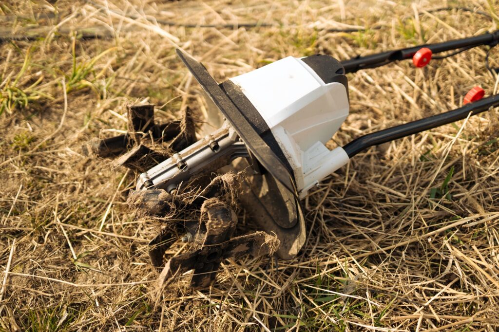 farmer plows the land with a cultivator. Agricultural machinery for tillage in the garden