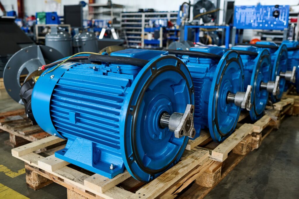 Row of new cylindrical parts of huge industrial machines on wooden crates