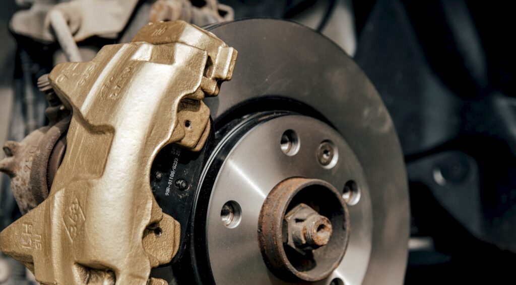 Close-up image of gold painted brake caliper on brake disc.