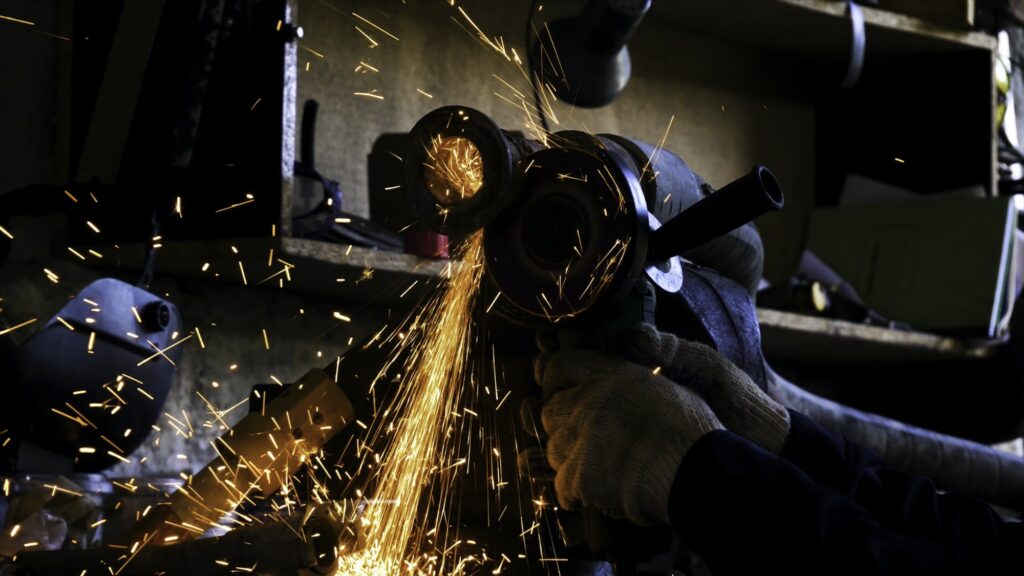 Close-up of worker cutting metal with grinder. Frame. Sparks while grinding iron. Circular cutting