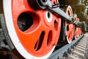 Red iron wheels of an old locomotive close-up. Retro steam locomotive on rails