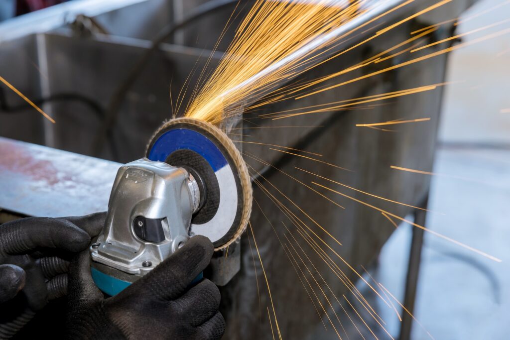 Using a grinding iron, the worker polished the metal surfaces