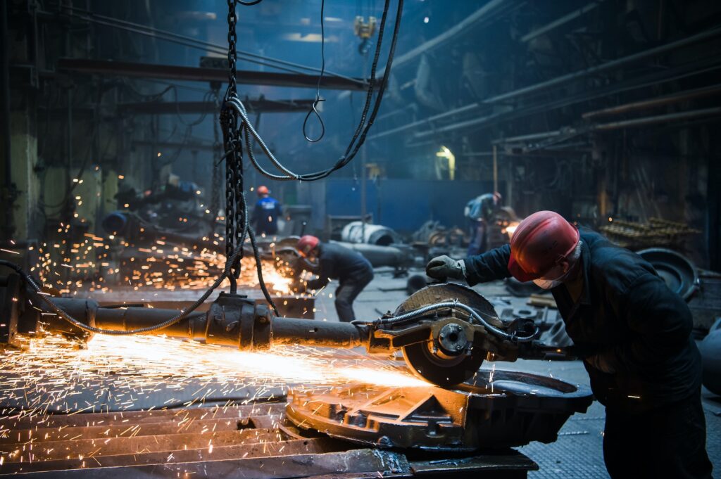 Welder used grinding stone on steel in factory with sparks