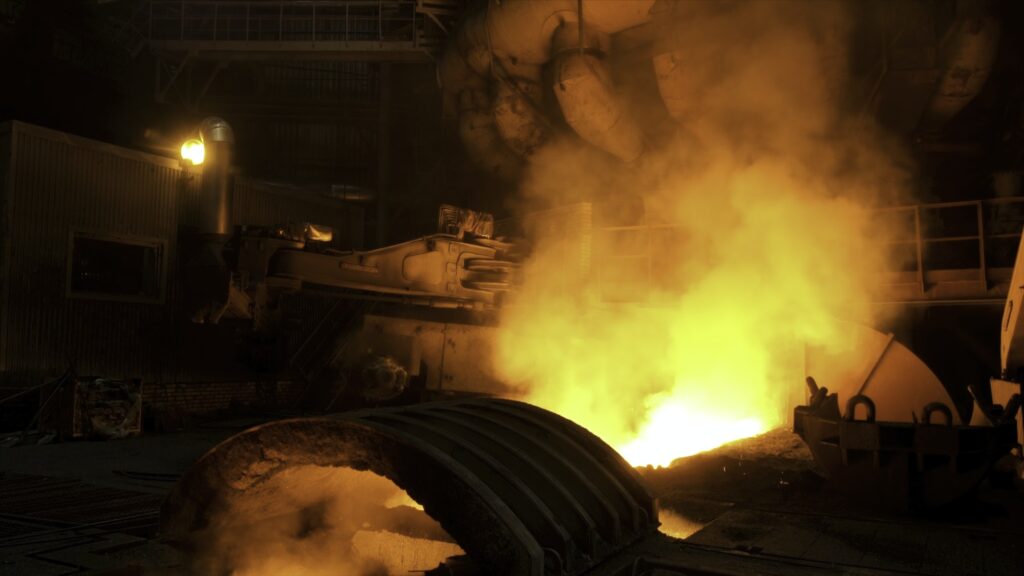 Close up for the electric furnace with melting metal and rising smoke. Stock footage. Metallurgical