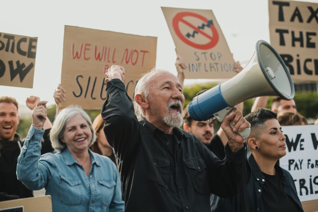 Crowd of people protesting against the economic situation with cardboard banners